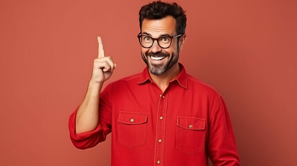 Fototapeta premium Portrait of smiling businessman pointing thumb at copy space for marketing over red background