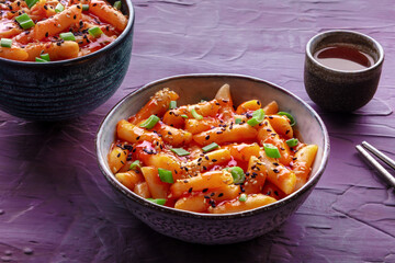 Tteokbokki or topokki and rabokki, Korean street food, spicy rice cakes in red pepper gochujang sauce, a popular dish in a cafe