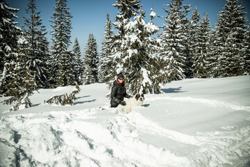 Fototapeta na wymiar happy woman playing with her dog in big snow