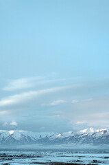 Cold snowy mountain landscape at sunset. Panoramic view of snowy mountain peaks and slopes of North Chuyskiy ridge at sunset. Russia, Siberia, Altai mountains.