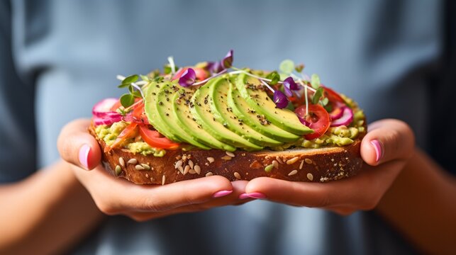 A vivid close-up of a hand gripping a fashionable avocado toast with vivid toppings, ideal for food vloggers and health-conscious people.