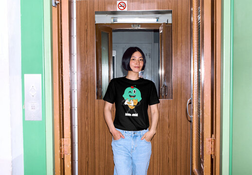 Mockup of Asian woman wearing customizable t-shirt in elevator, flash