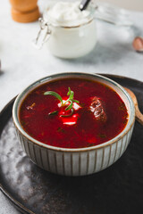 Traditional Ukrainian beet soup - borscht on the grey background vertical photo