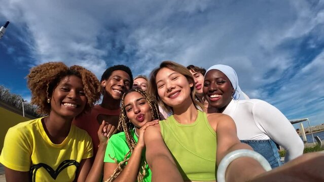 millenial generation chines girl with multiethnic friends taking selfie outdoors