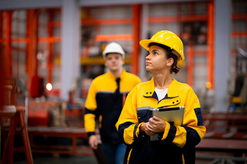 Team of young male and female engineers in a metal sheet factory Responsible work is being inspected at the actual work site.