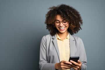 smiling african american businesswoman using smartphone isolated on grey