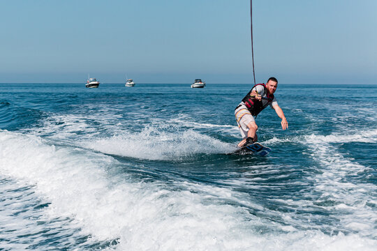 A surfer floats on a board on the waves of the sea.