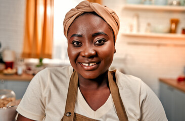 Culinary time. Portrait of pleasant afro woman with diastema between upper teeth smiling at camera...