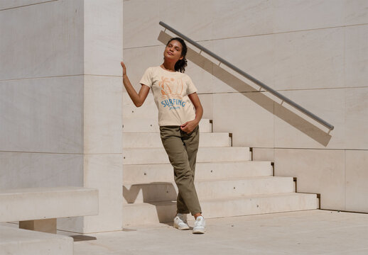 Mockup of woman wearing customizable t-shirt by steps outdoors