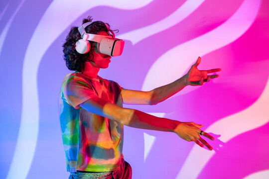 Engaged latin man in VR world with tie-dye and wavy backdrop