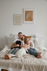 Couple in love, pregnant girl and guy with dogs on bed, bright photo