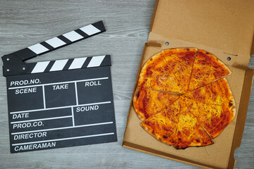 clapper board of video cinema and Fresh Homemade Algerian Pizza Margherita on wood table