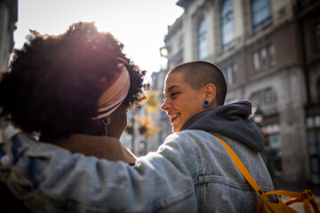 Lesbian couple sharing a joyous moment on a city street
