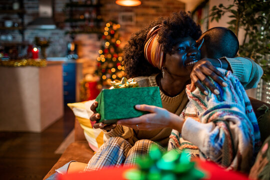 Joyful lesbian couple exchanging gifts during the Christmas season