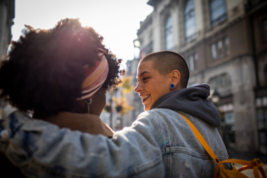 Lesbian couple sharing a joyous moment on a city street