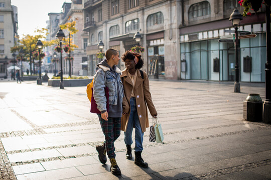Lesbian couple sharing a joyous moment on a city street