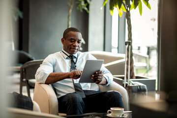 Businessman using the tablet at the hotel lobby