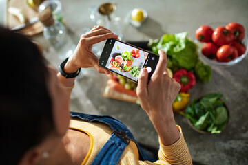 Young Woman Captures Fresh Ingredients on Smartphone in the kitchen
