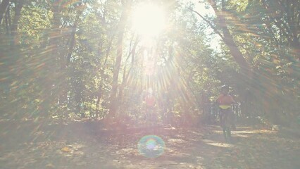 A boy in a bicycle helmet rides a bicycle on a path in the park. active recreation of a child riding a bike in the forest. High quality 4k footage