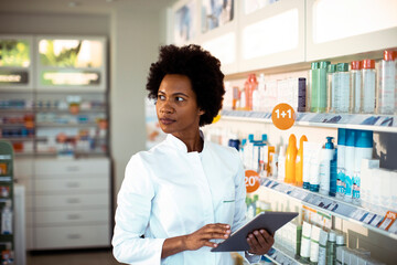 Focused pharmacist reviews inventory in a modern pharmacy