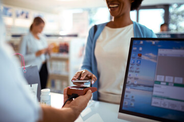 Close up of customer makes a digital payment at a pharmacy counter