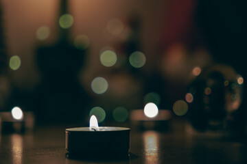 A small candle on a bokeh background