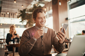 Young businessman looking at a smartphone in a cafe