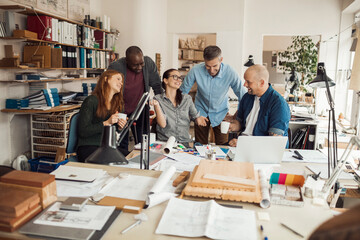 Diverse team of architects collaborating with enthusiasm in a studio
