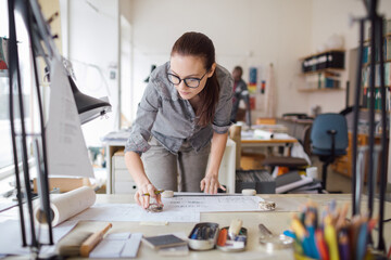 Thoughtful architect pondering over design blueprints in a vibrant workspace