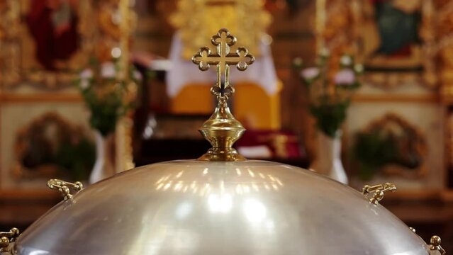 Aluminium church font, large bowl, with golden cross and saint water for the baptism of babies in Orthodox Church temple, Christening ceremony. Concept of rituals, sacraments of the Christian religion