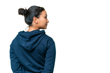 Young Uruguayan woman over isolated chroma key background in back position and looking back