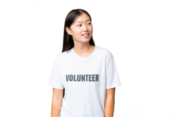 Young volunteer woman over isolated chroma key background looking to the side and smiling