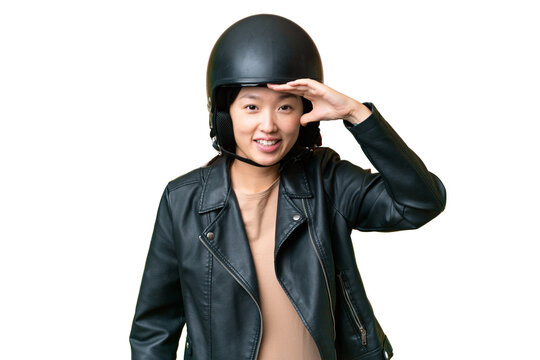 Young Asian woman with a motorcycle helmet over isolated chroma key background looking far away with hand to look something
