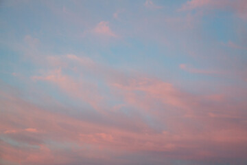 Blue sky with pink sunset clouds. Cloud texture, background.
