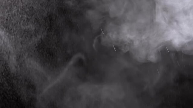 Explosion of Icy Water Droplets in Moving Dense Clouds of Steam in Empty Space. Texture. Flash. Storm clouds. Smoke swirl. Effect of gray icy thunderclouds with rain and snow. Blurred motion. Weather.