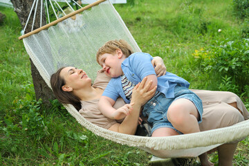 Embracing the Present: A mindful pause between a mother and her child creates an intimate space within the comfort of a hammock.