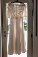 Wedding gown hanging on a door