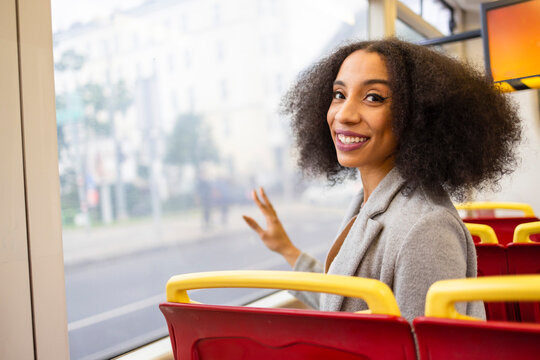 Happy afro woman while sitting on bus seat