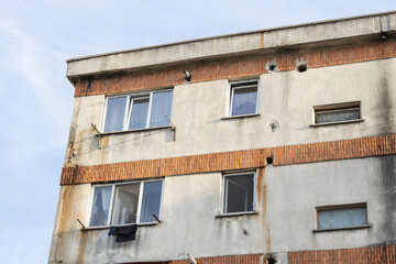 Fototapeta na wymiar Old apartment block from communist era in Eastern Europe. Communist socialist architecture style flat. Dreary and depressive rust-eaten building.