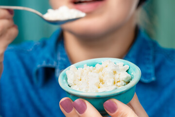 Close-up of a bowl of cottage cheese in the hands of a Caucasian woman. Focus on a bowl of cottage...