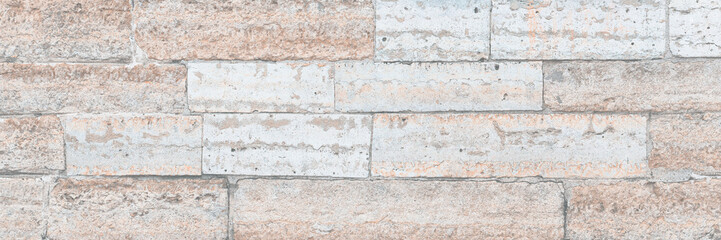 Old wall lined with decorative stone. Weathered rough surface of stones. Beautiful masonry in a classic style. Vintage texture great for background and design.