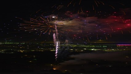Wide shot of fireworks exploding in sky over cityscape at night  - vertical video / Pleasant Grove, Utah, United States