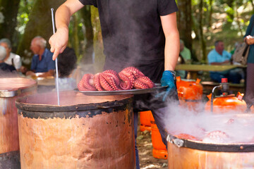 Anonymous chef presenting steamed octopus