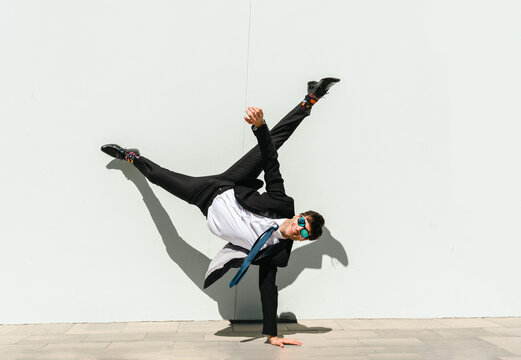 Flexible and cool businessman doing acrobatic trick