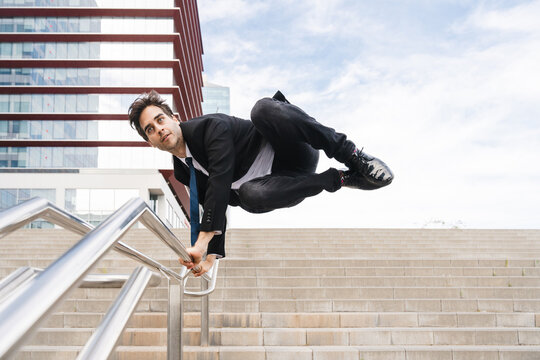 Flexible and cool businessman doing acrobatic trick