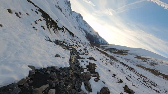 FPV drone follows the course of a small mountain river during sunrise
