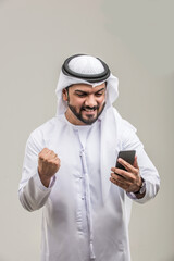 Arabian man wearing traditional emirati dishdasha kandura in studio - Portrait of middle-eastern male adult with beard