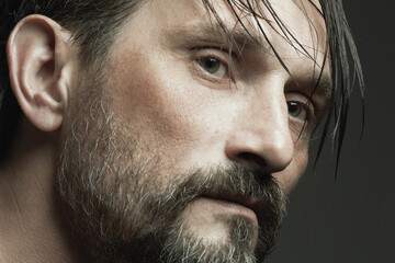 Fabulous at any age concept. Profile portrait of 45-year-old man standing over dark gray background. Wet hair. Close up.  Studio shot