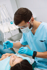 male dentist making treatment in modern clinic