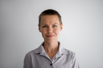 Portrait of a woman with a short haircut looks smiling at the camera. Manager, resume photo.